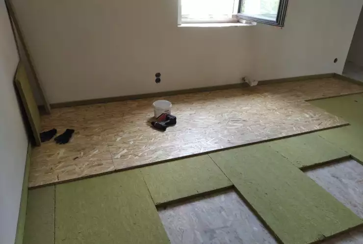 první vrstva OSB + kročejová izolace v ploše i kolem obvodu + druhá vrstva osb